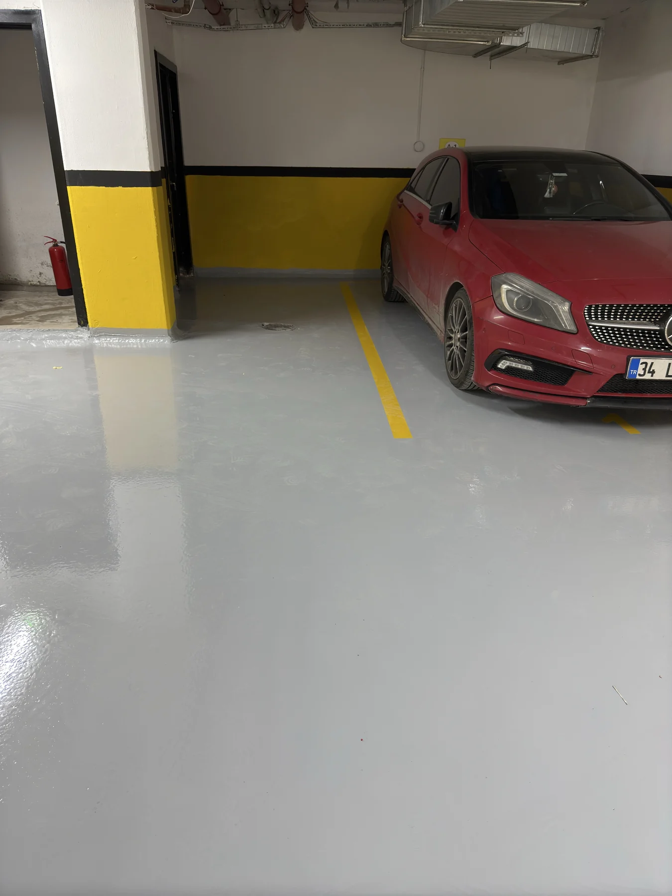 Park etmiş araç yanında gri epoksi yer kaplamalı otopark